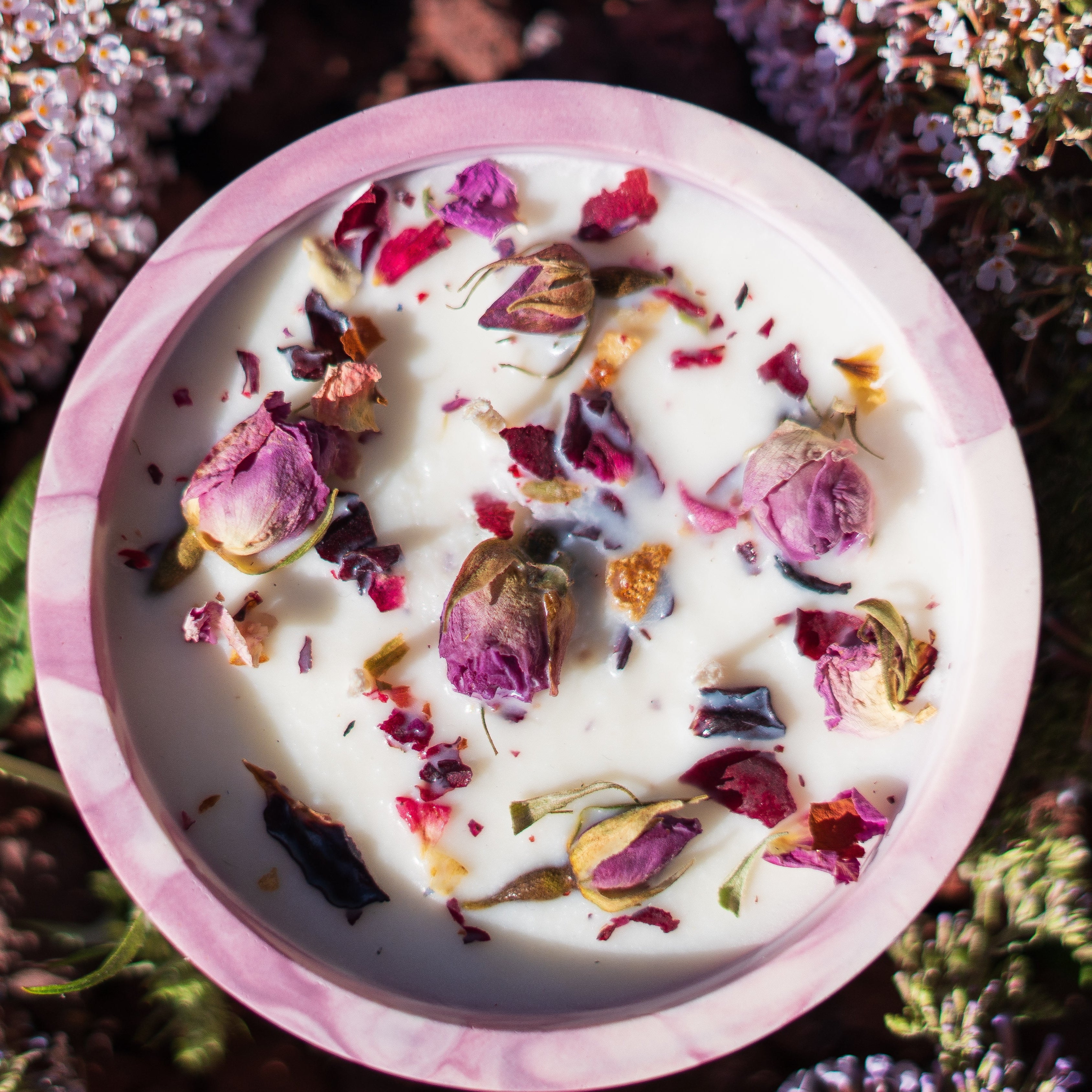 Pink bowl with dried flowers on a bed of pink flowers